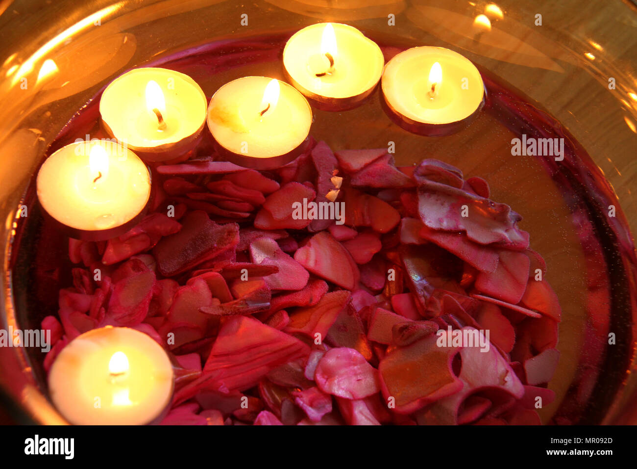 Burning candles floating on water in small bowl Stock Photo Alamy