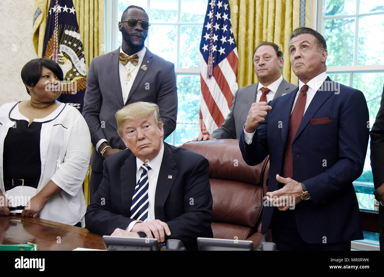 United States President Donald J. Trump listens as actor Sylvester Stallone gestures during a signing ceremony to grant posthumous pardon to former heavyweight champion Jack Johnson in the Oval Office of the White House on May 24, 2018 in Washington, DC. Credit: Olivier Douliery/Pool via CNP /MediaPunch Stock Photo