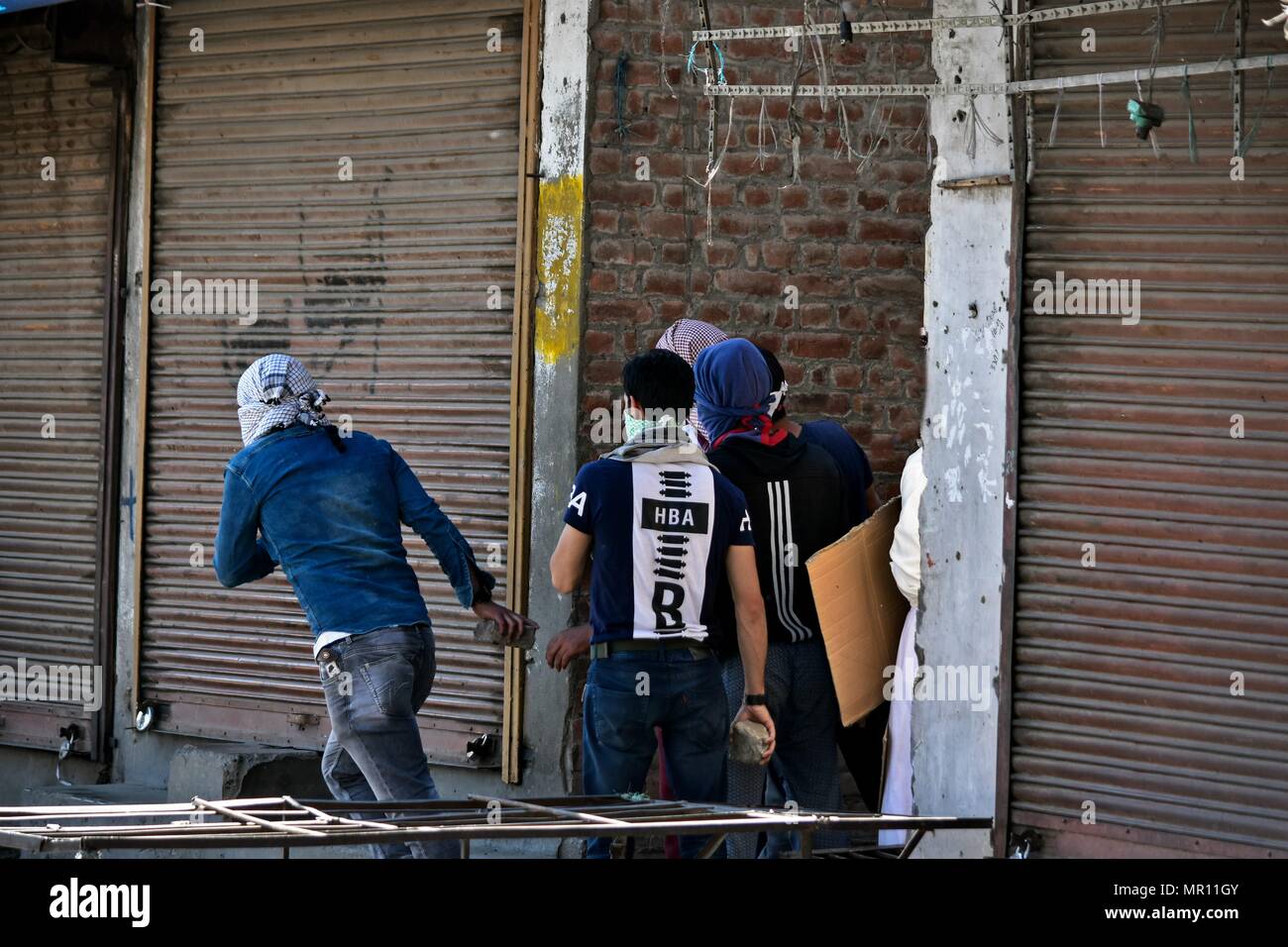 Kashmiri protesters prepare to throw stones at policemen during clashes in Srinagar, Indian administered Kashmir.  Fierce clashes broke out between government forces and Kashmiri protesters in Srinagar on Friday. Scores of people were injured after government forces fired shotgun pellets and smoke shells on Kashmiri protesters who gathered after the mandatory Friday congregational prayers. Credit: SOPA Images Limited/Alamy Live News Stock Photo