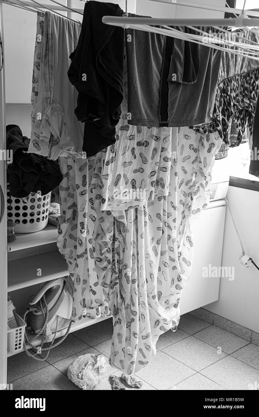 clothes hanging rack drying hanger indoors  black white Stock Photo
