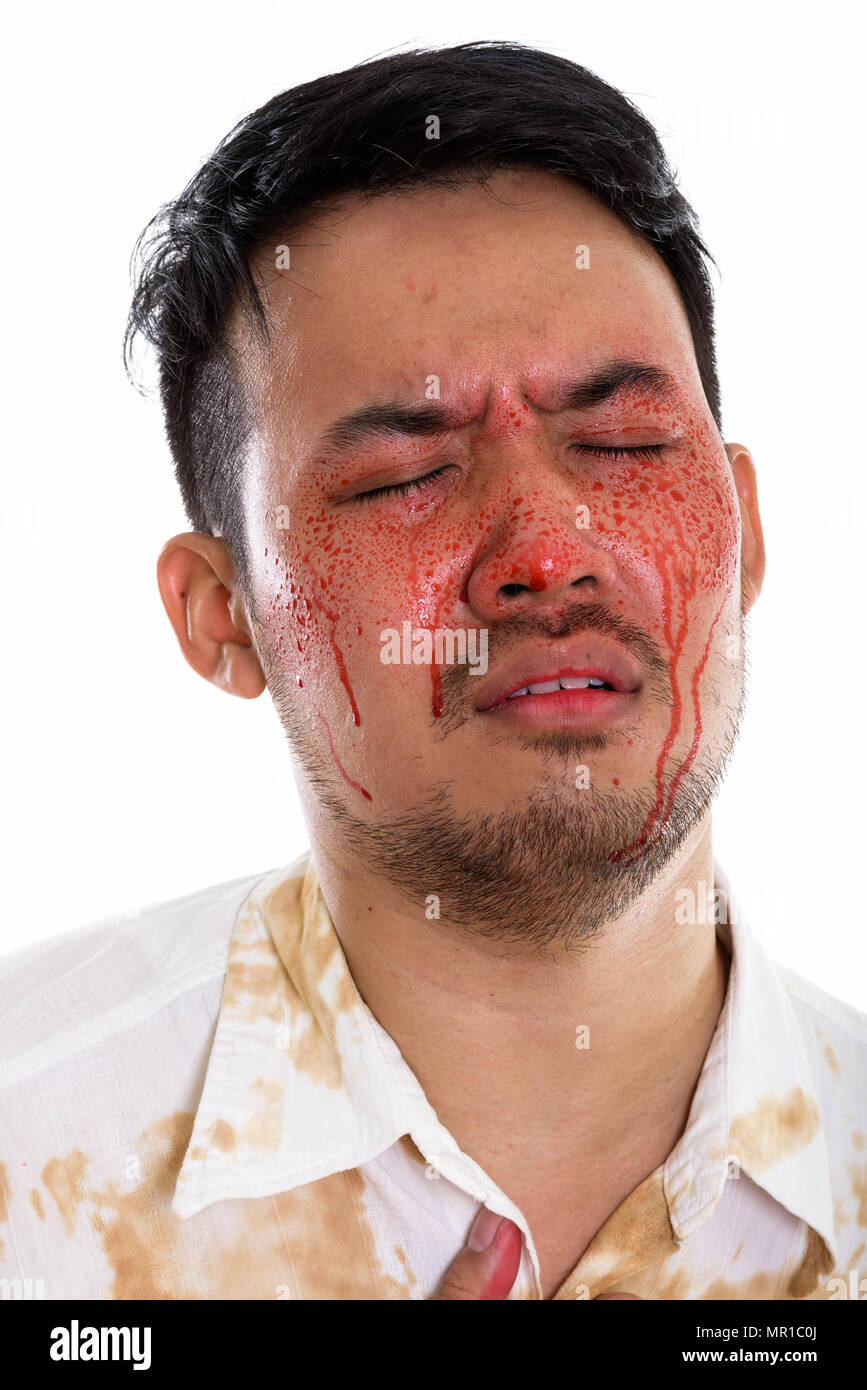 Face of young crazy Asian man looking sad with eyes closed and b Stock Photo
