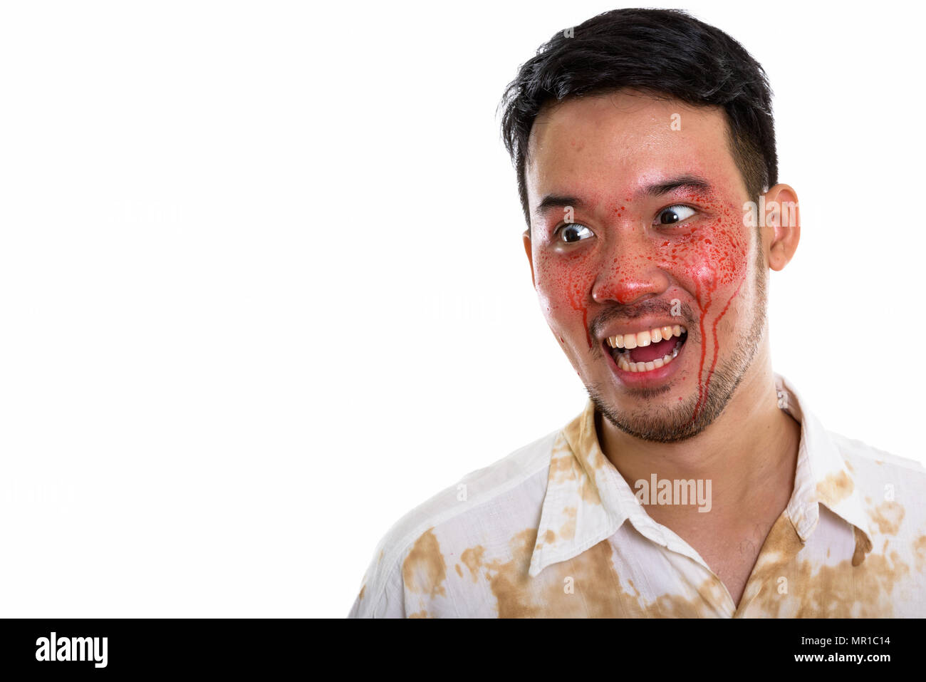 Close up of thoughtful happy crazy Asian man smiling and laughin Stock Photo