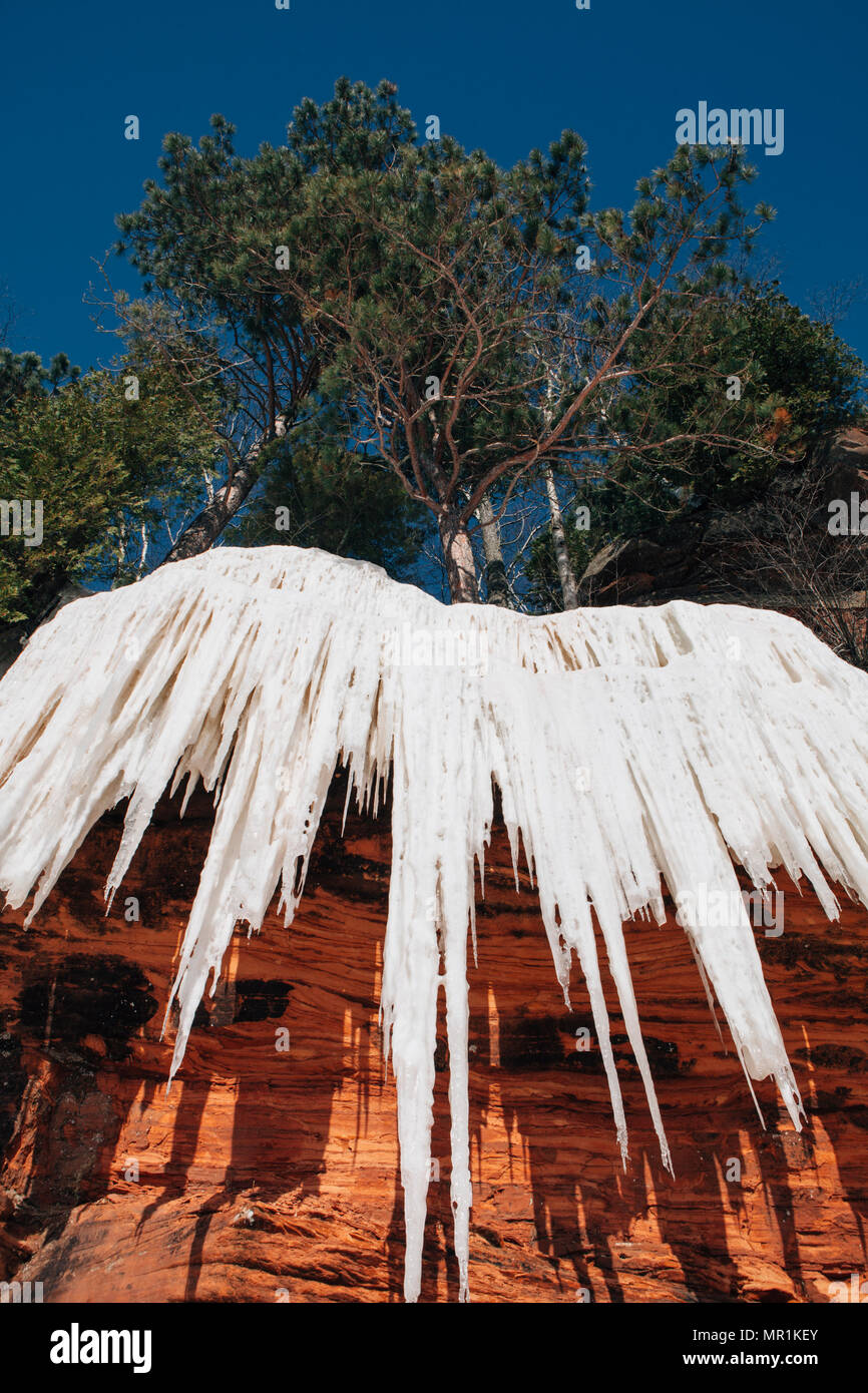 Red rock caves are ice covered along the shoreline of the Apostle