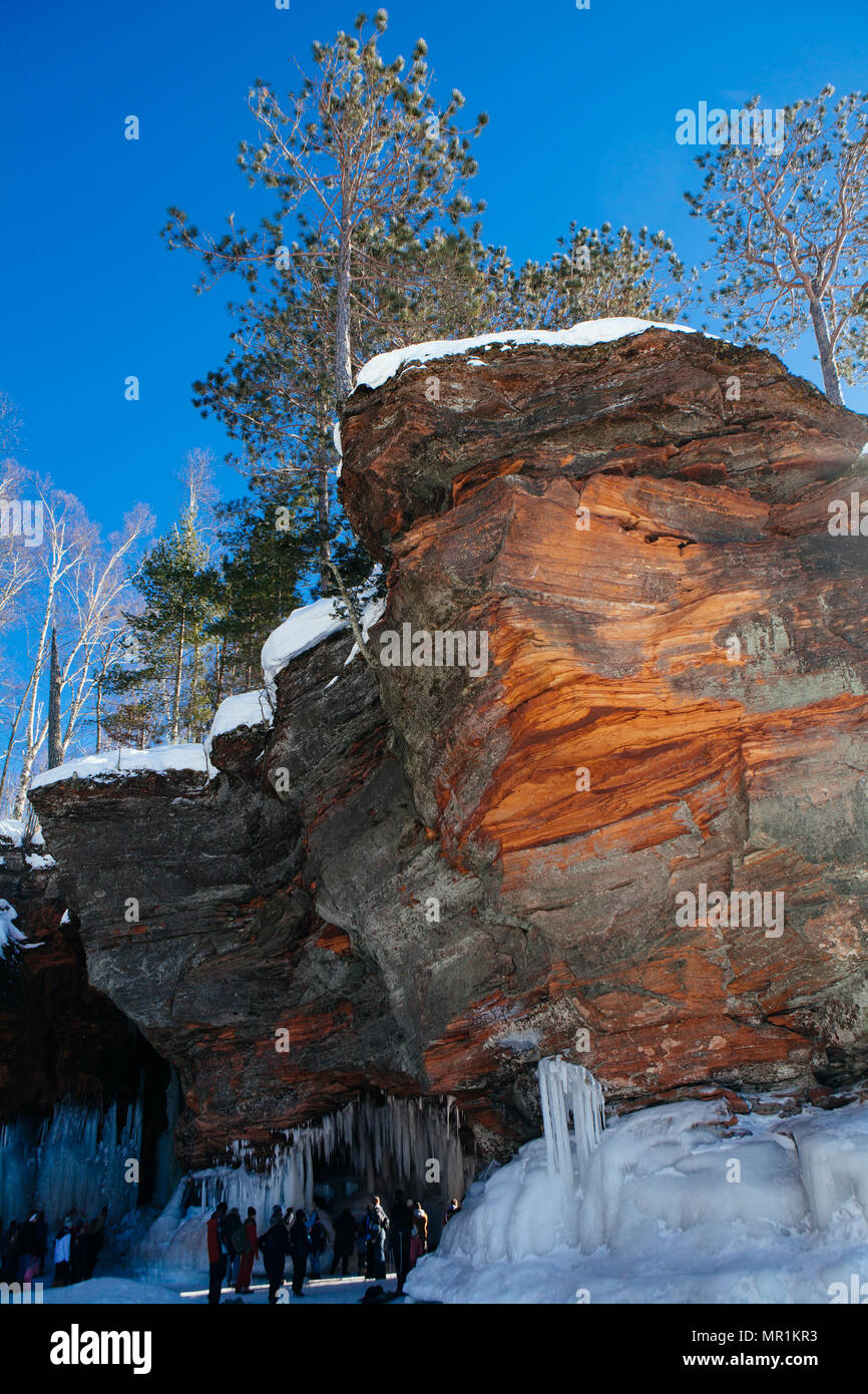 People visit the Apostle Islands National Lakeshore ice caves on a sunny winter day in Bayfield, Wisconsin, USA Stock Photo