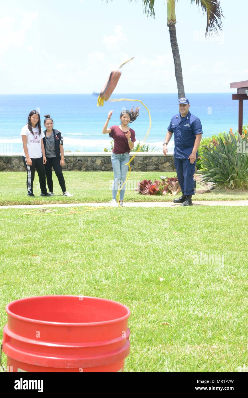 Petty Officer 1st Class Brad Wolf, a maritime enforcement specialist at  Coast Guard Sector Honolulu, shows Michika Soma, a 7th grader from La  Pietra - Hawaii School for Girls how to throw