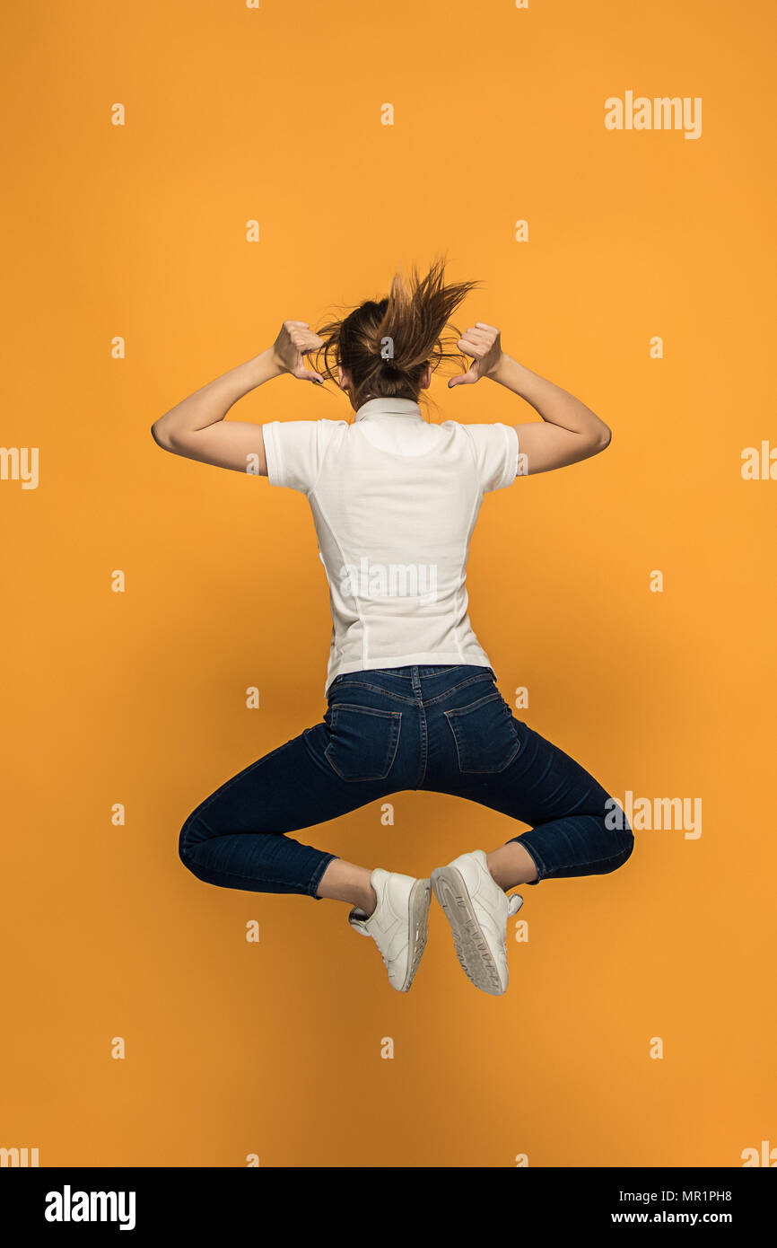 Closeup of young woman's body in empty white t-shirt on orange background. Mock up for disign concept Stock Photo
