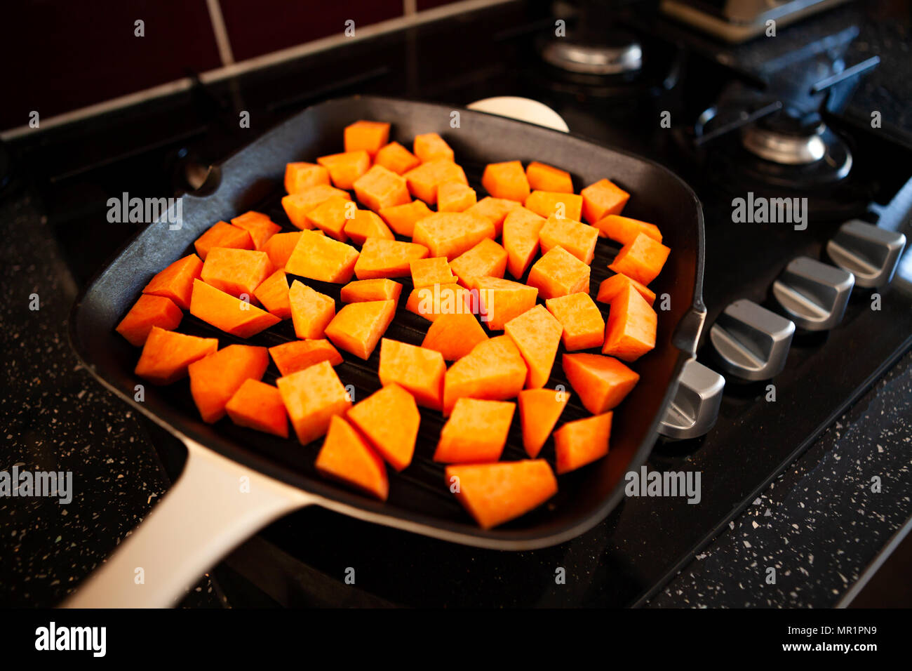 Sweet potato being cooked in a griddle pan/broiler Stock Photo Alamy