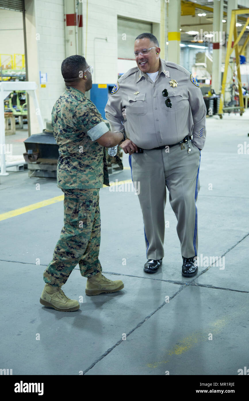 (Left) Colonel Sekou Karega, commanding officer, Marine Corps Logistics Base Barstow, Calif.: chats with Capt. John Tyler, commander, Barstow California Highway Patrol Station; during an April 28 tour of Production Pant Barstow, Marine Depot Maintenance Command aboard the Yermo Annex of MCLB Barstow. Stock Photo