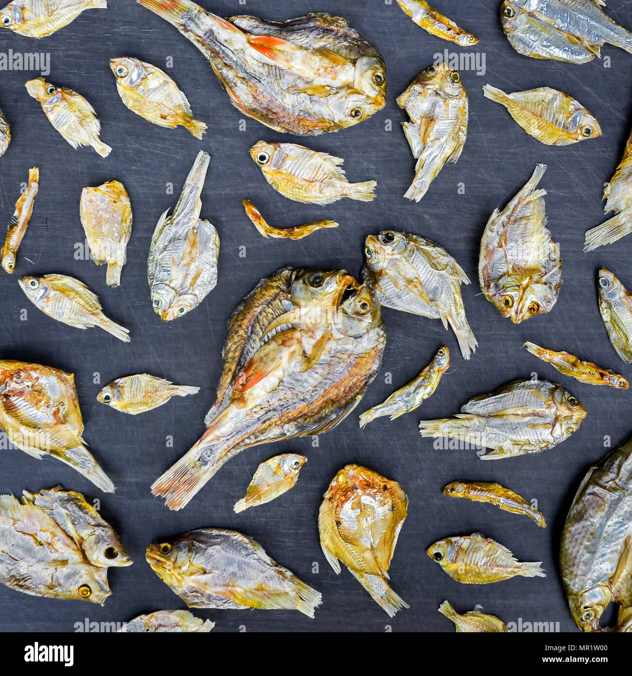 Dry fish and sunny on black wooden floor, small dried fish and pattern ...