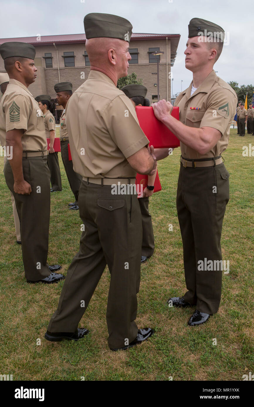 U.S. Marine Lance Cpl. Nicholas Greenisen receives a Marine of the
