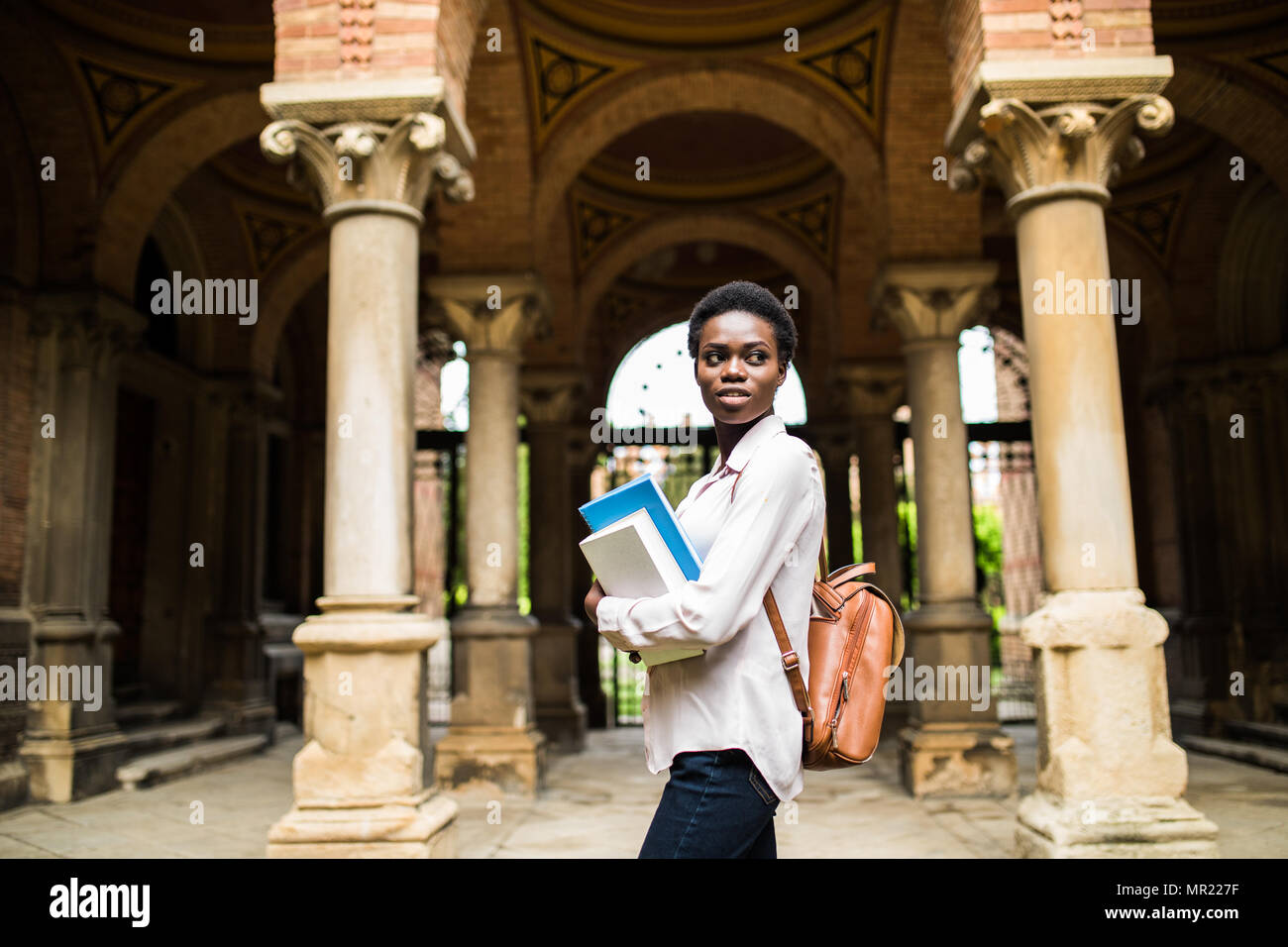 Portrait of a cheerful smiling african student girl wearing backpack ...