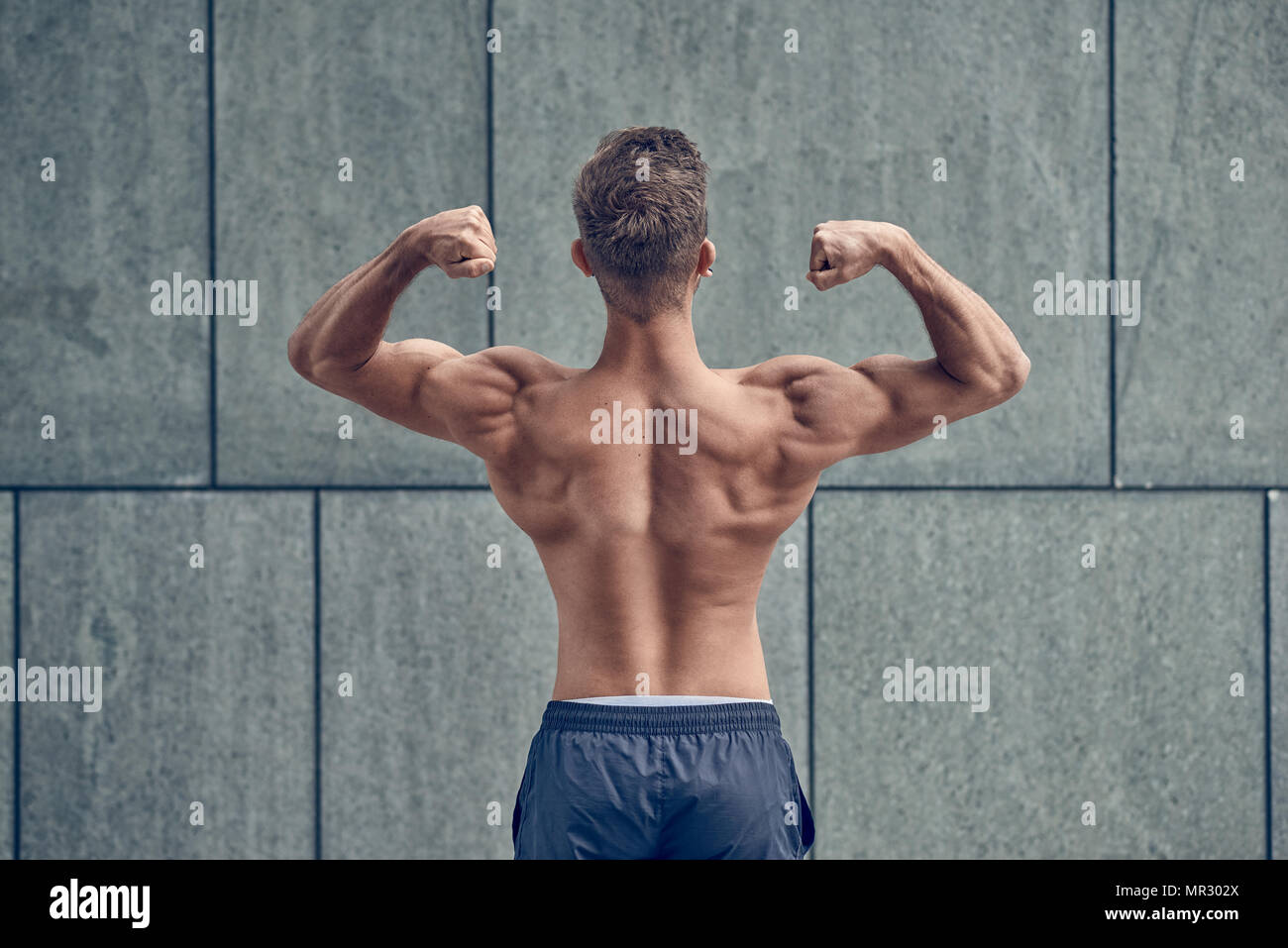 Young male bodybuilder posing with his back to the camera Stock Photo