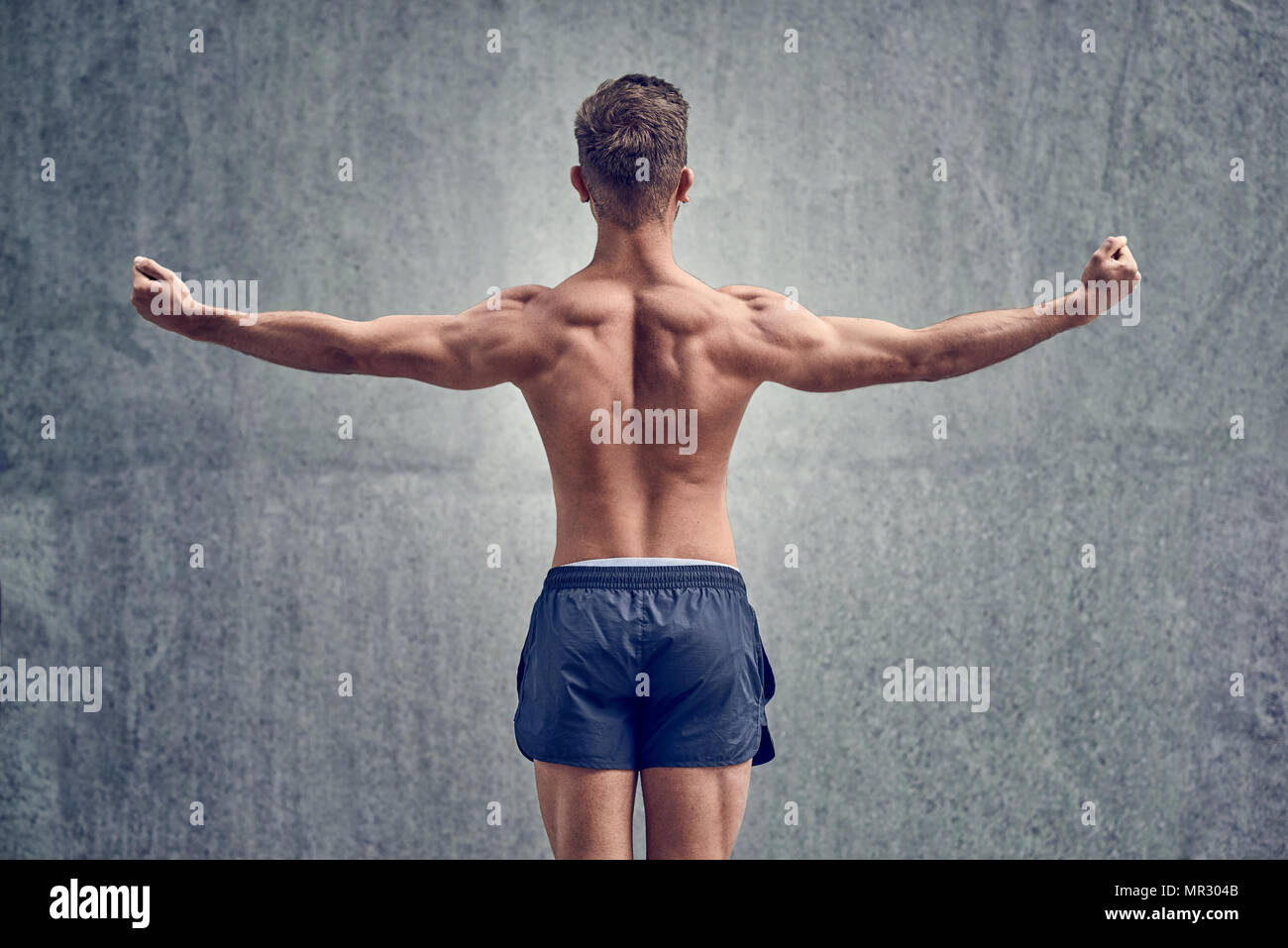 Young male bodybuilder posing with his back to the camera Stock Photo