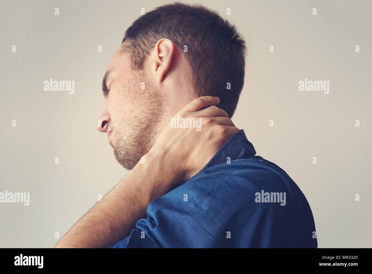 businessman holding a phone and her neck with pain. young guy holding