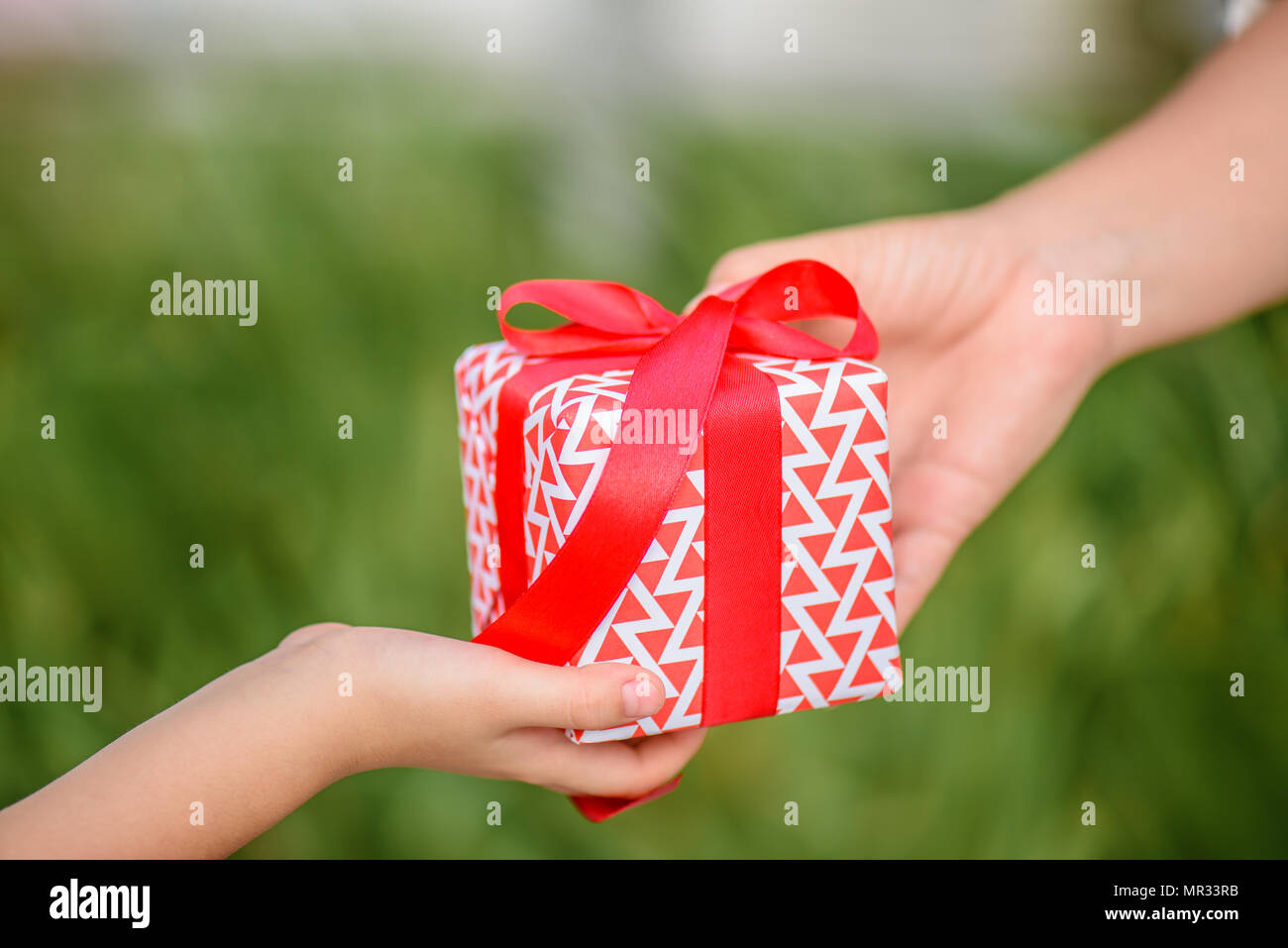 Mother hand giving a gift box to her child. Holidays, present