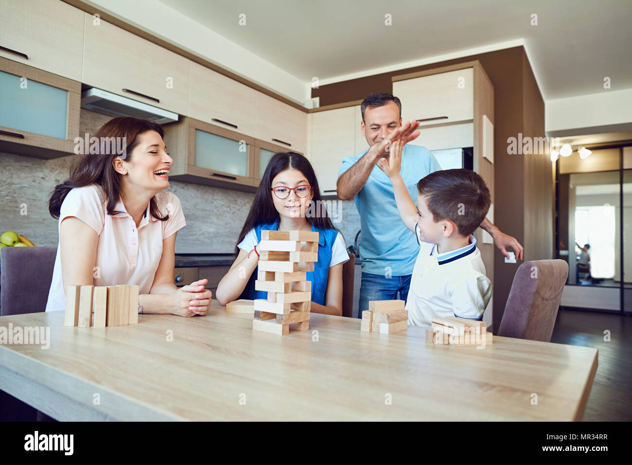 A cheerful family plays board games at home.  Stock Photo
