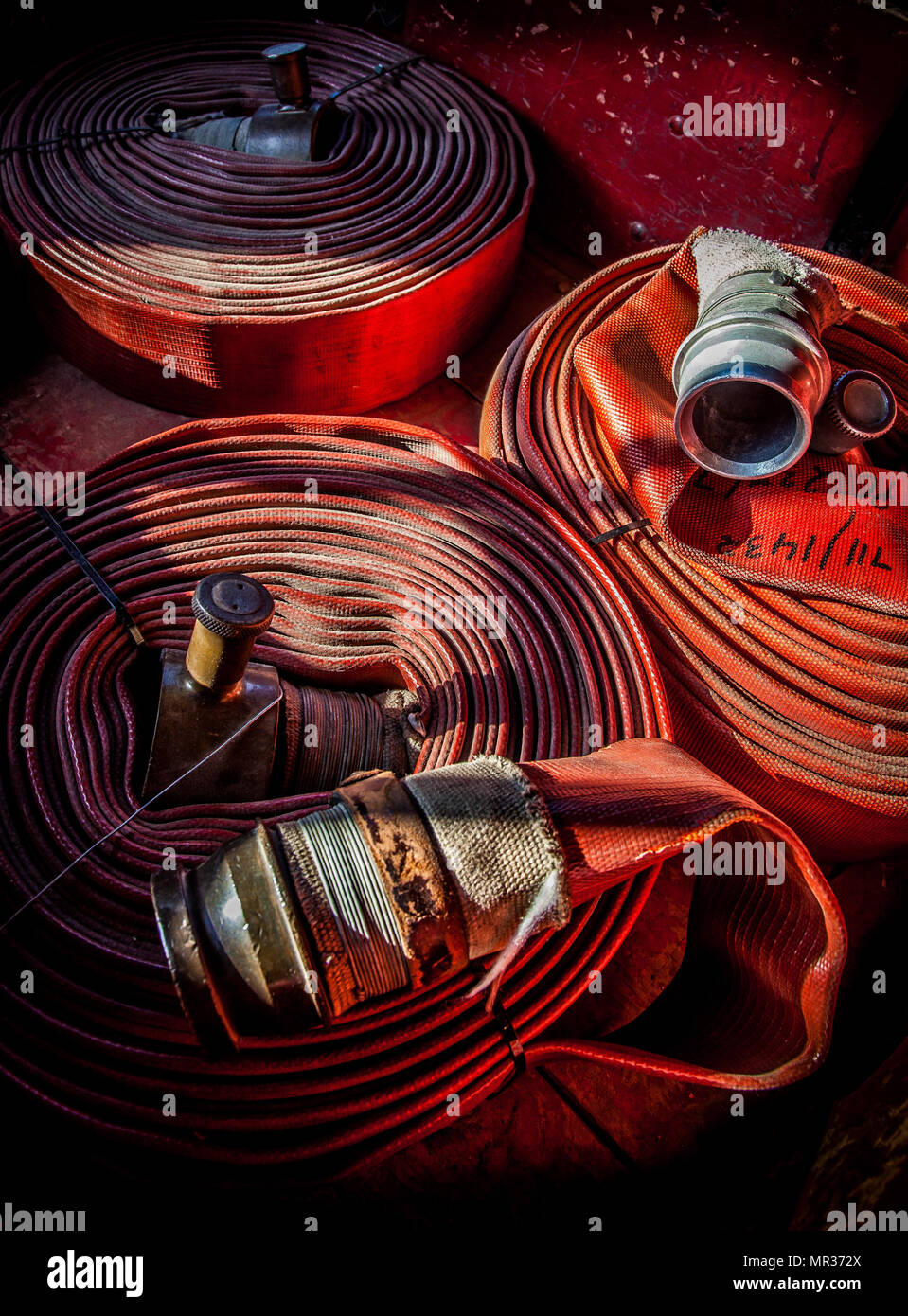 Old fire hoses rolled / coiled up with brass connections Stock Photo