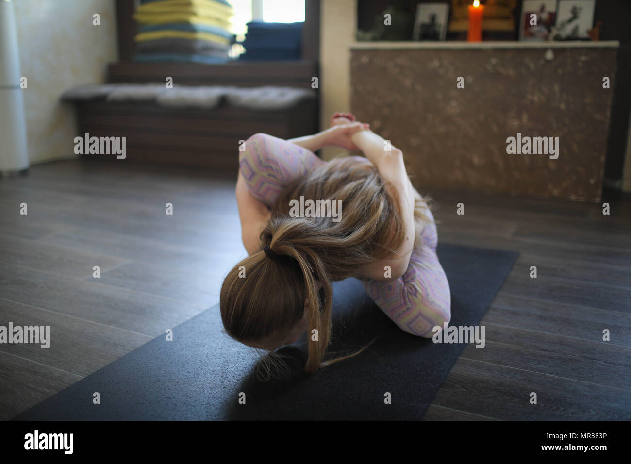 Young woman practicing Ashtanga yoga in yoga class. Stock Photo