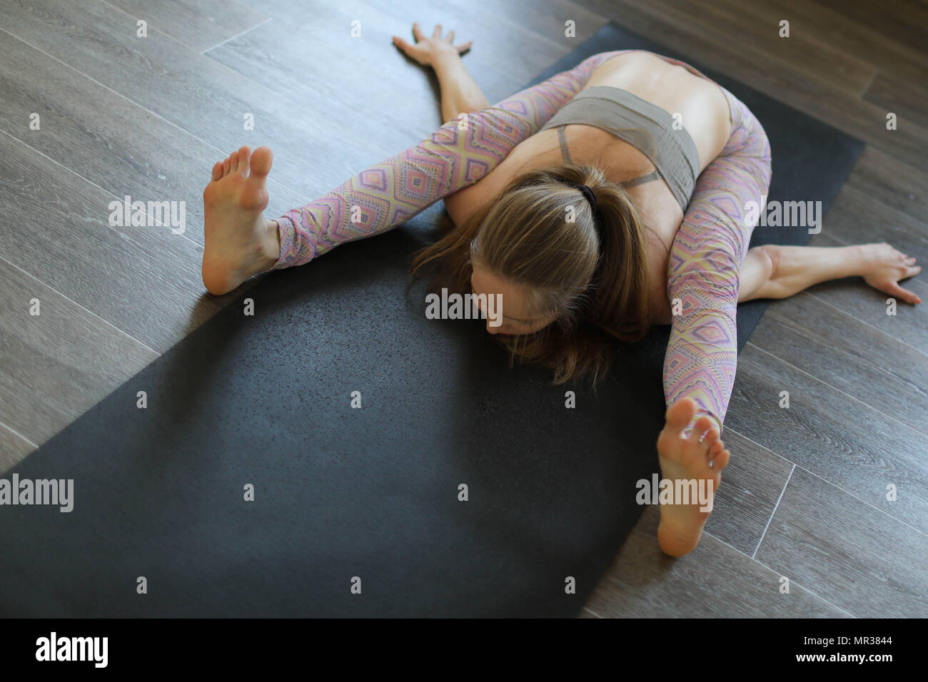 Young woman practicing Ashtanga yoga in yoga class. Stock Photo