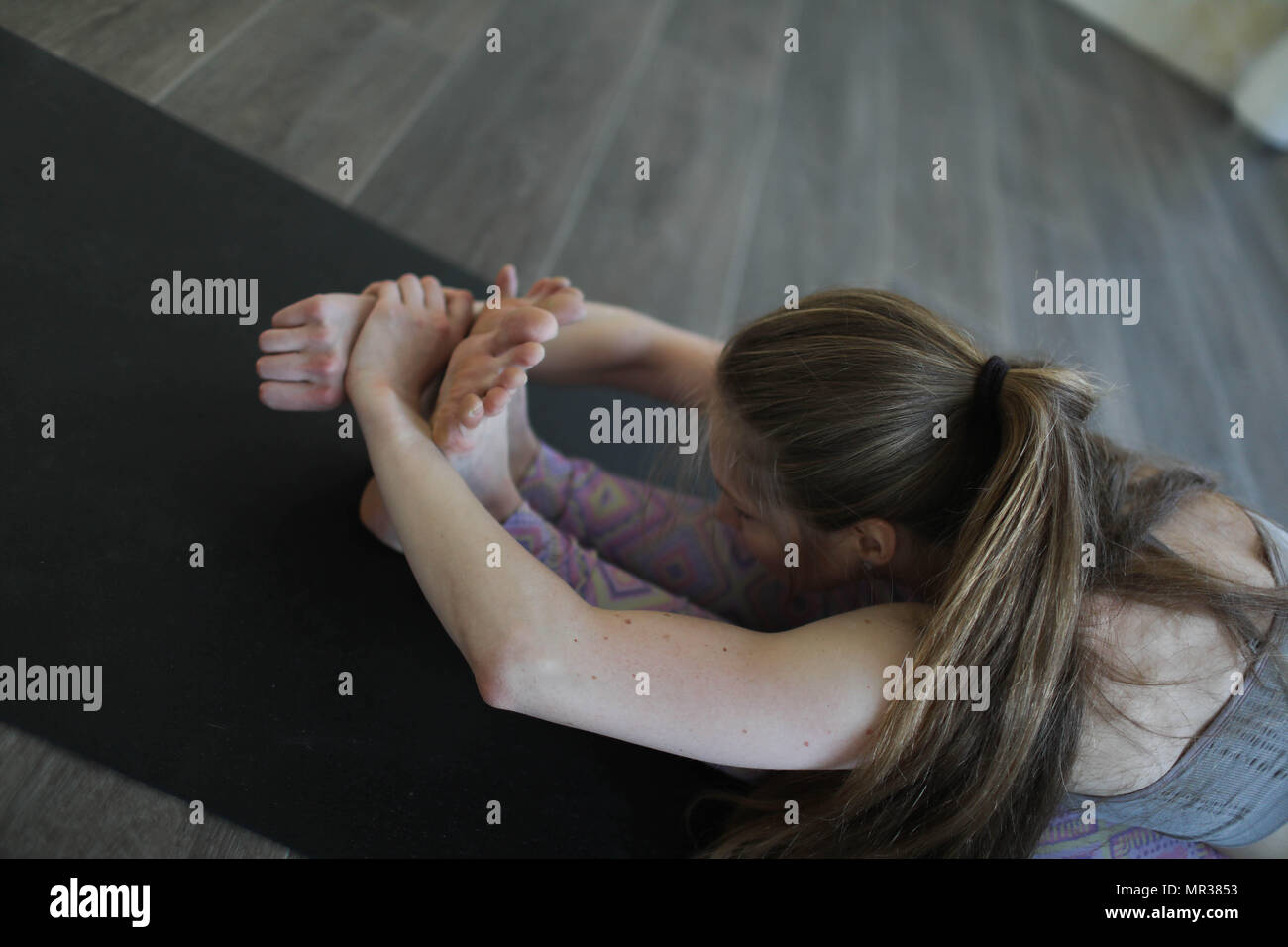 Young woman practicing Ashtanga yoga in yoga class. Stock Photo