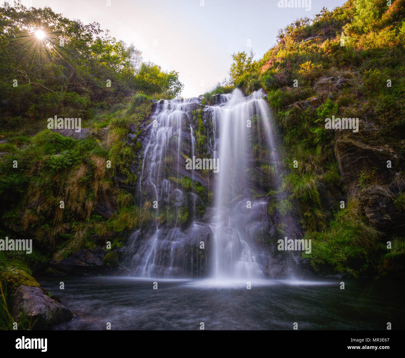 Waterfall with sunbeams Stock Photo