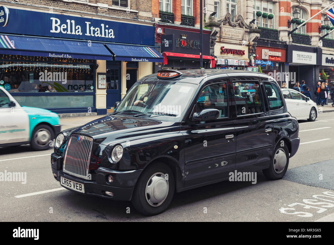 London, UK - April 2018: London taxi cab driven on Shaftesbury Avenue, a major street in the West End of London near Piccadilly Circus Stock Photo