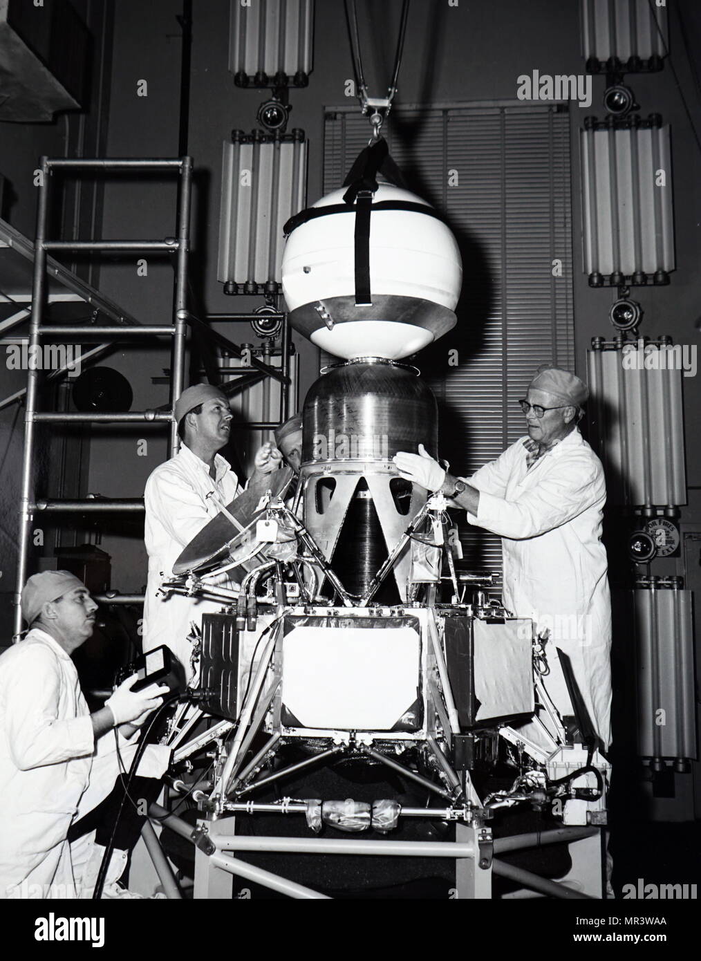 Photograph of payload engineers performing tests and installing a capsule and retro motor of Ranger III. Dated 20th century Stock Photo