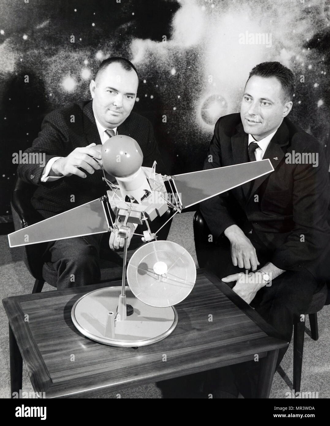 Photograph of an advanced model of the Ranger 3 spacecraft and the lunar capsule. Also pictured is Dr. Donald B. Duncan (left), general operations manager of Space System Operations at Aeronutronic Division of Ford Motor Company, where the capsule is being deployed; and James D. Burke, Ranger project manager at the Jet Propulsion Laboratory. Dated 20th century Stock Photo