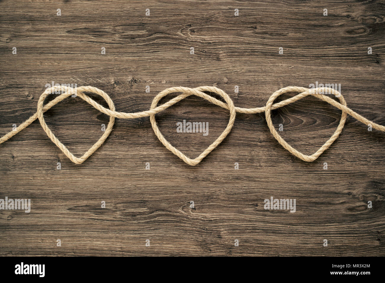 Three heart rope shapes  on old wood Stock Photo