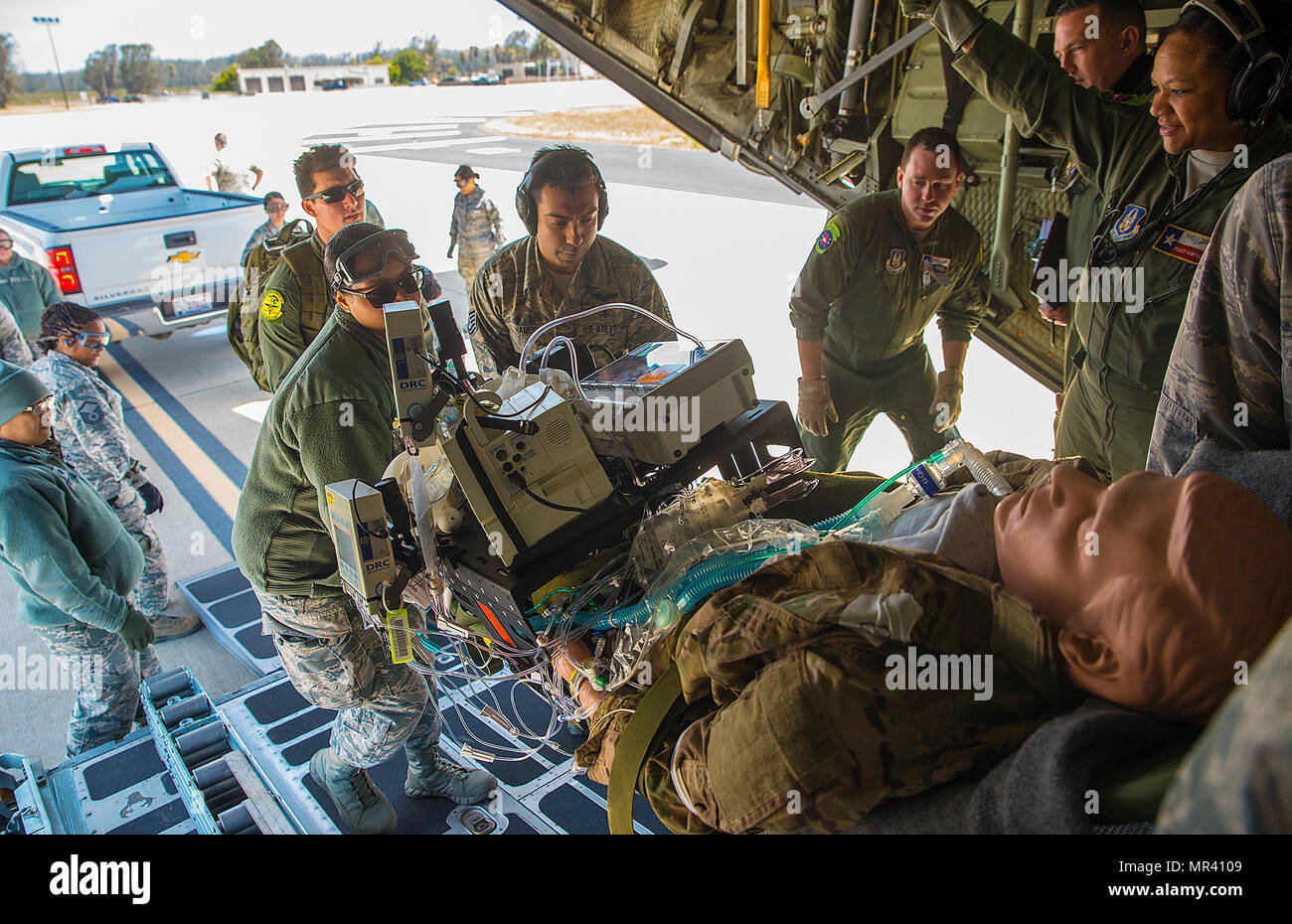 A simulated critical care patient is loaded onto a C-130 Hercules ...