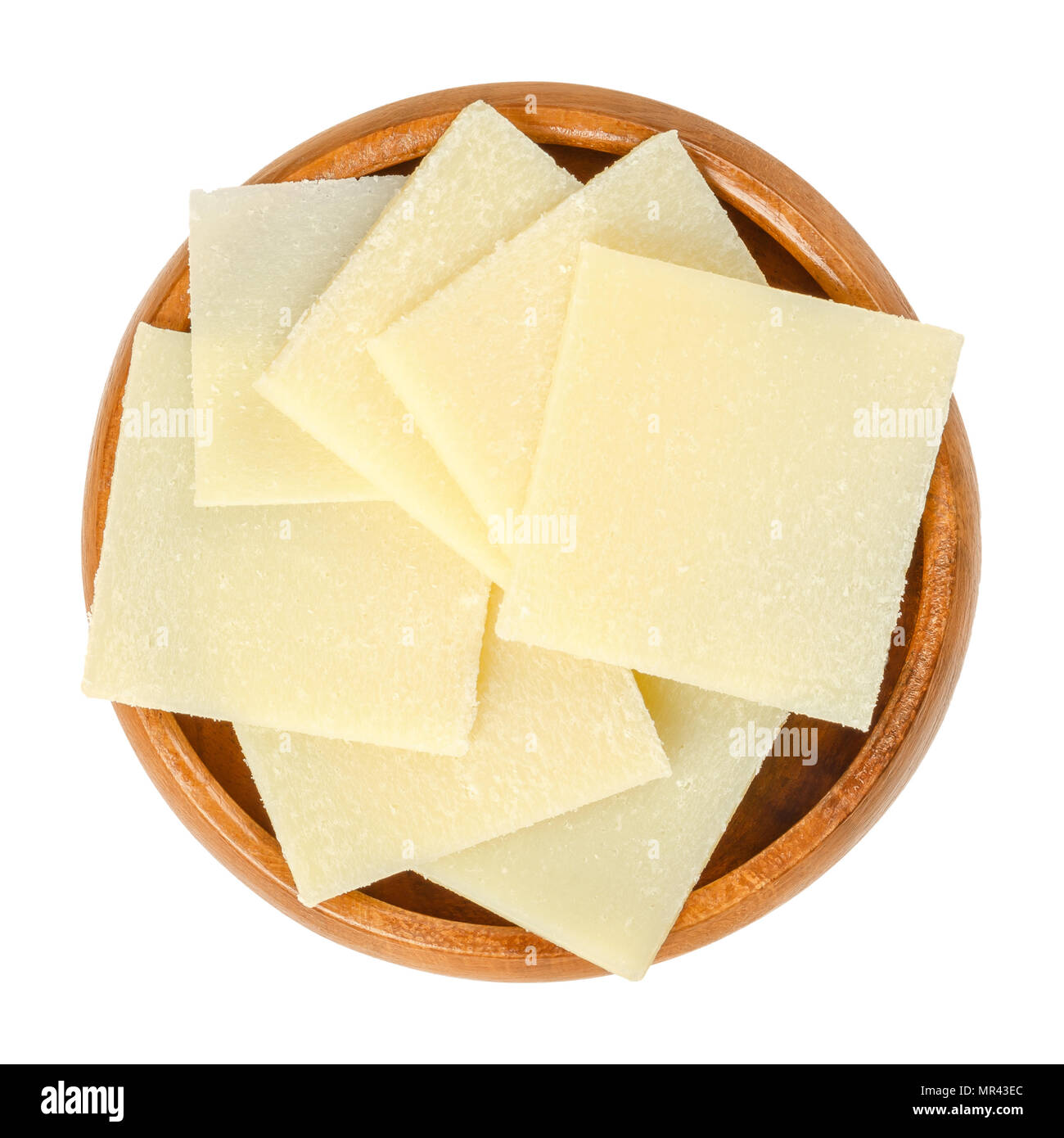 Parmesan cheese pieces in wooden bowl. Parmigiano-Reggiano. Italian hard, granular cheese, of slightly yellow color, made of unpasteurized cow milk. Stock Photo