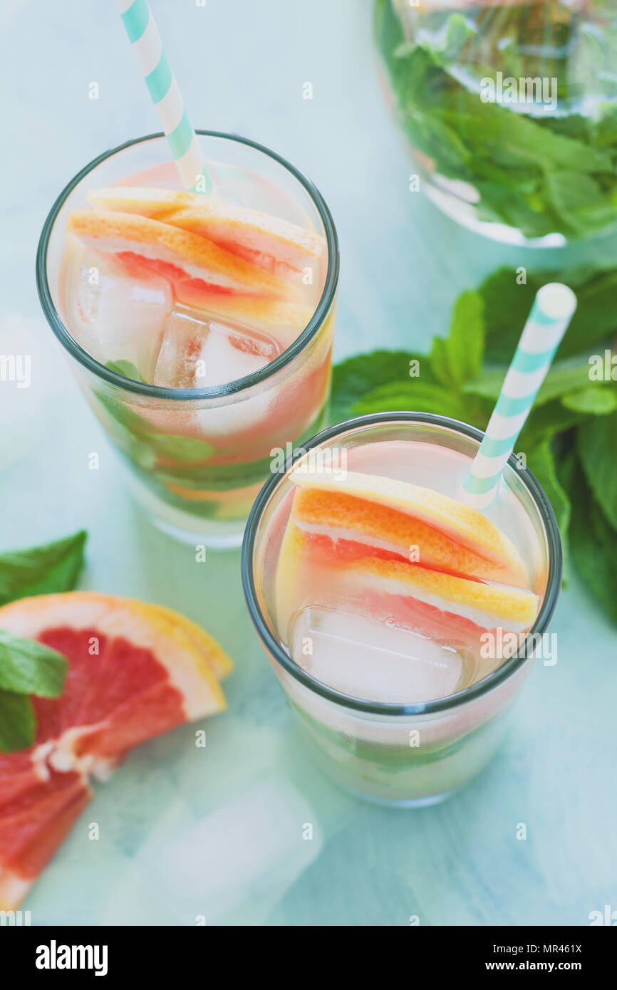 Refreshment grapefruit cocktail with mint on mint color background