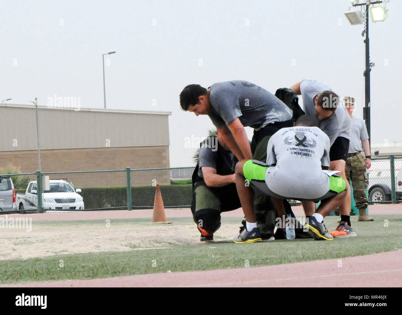 Spc. Cory Brunt, a Soldier with Joint Task Force Atlas (Counter-Improvised Explosive Devices), Combined Joined Task Force-Operation Inherent Resolve, hunches over to regain strength and allows his team mates to remove a bomb suit after finishing the Explosive Ordnance Disposal memorial 5k run, May 5, Camp Arifjan, Kuwait. The 5k was held to commemorate and shadow the EOD memorial ceremony held at Eglin Air Force Base, Florida. (U.S. Army photo by Sgt. Kimberly Browne, Army Central Public Affairs) Stock Photo