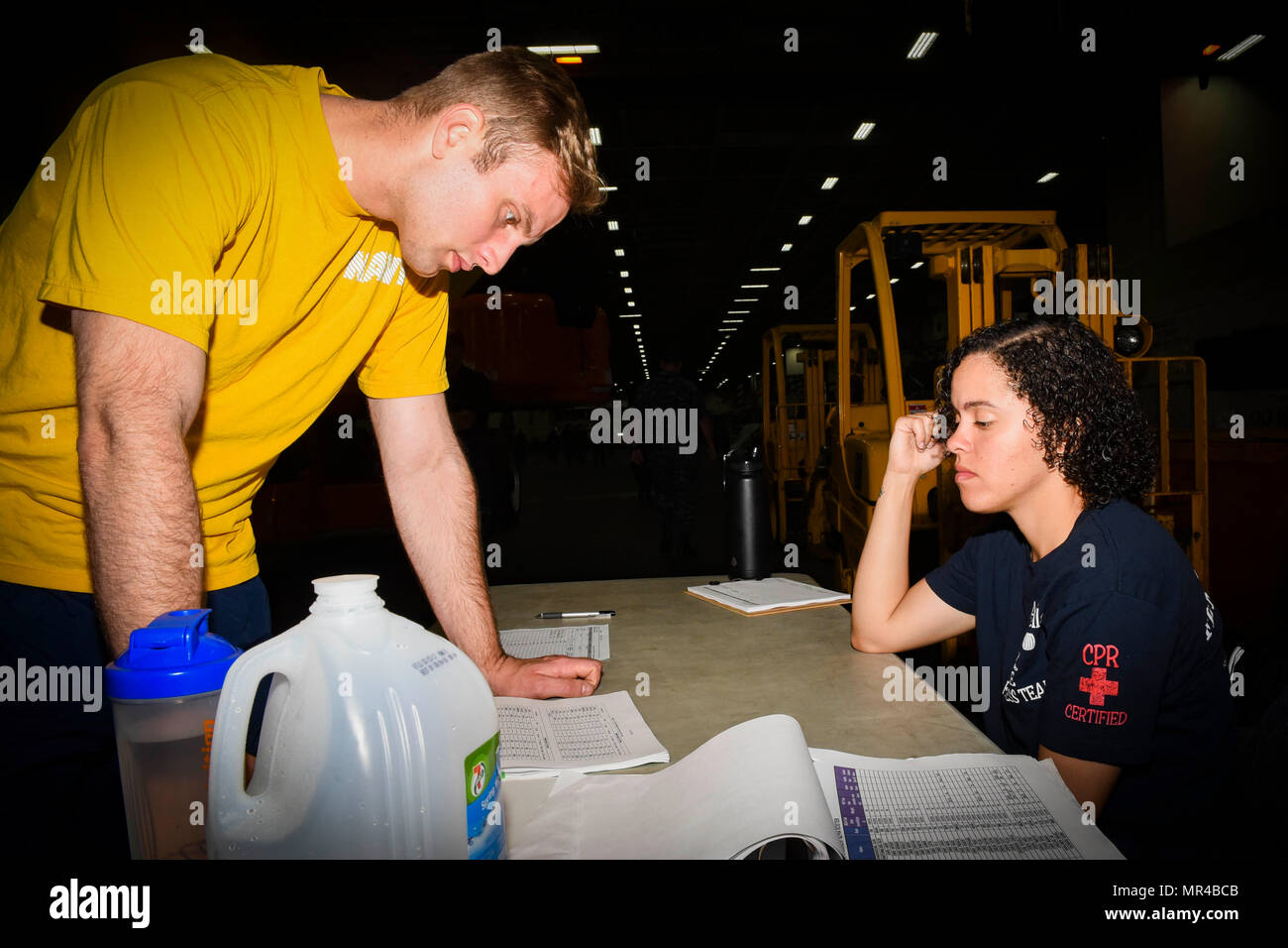 170505-N-LA456-037  NORFOLK, Va. (May 5, 2017) Aviation Ordnanceman 3rd Class Whitney Trella, right, from Spartanburg, S.C., shows physical readiness test (PRT) standards to Interior Communications Electrician Seaman Derek Walshe, from Syracuse, N.Y., in the hangar bay of the aircraft carrier USS Dwight D. Eisenhower (CVN 69) (Ike). Ike is currently pier side during the sustainment phase of the Optimized Fleet Response Plan (OFRP). (U.S. Navy photo by Mass Communication Specialist Seaman K. A. DaCosta) Stock Photo
