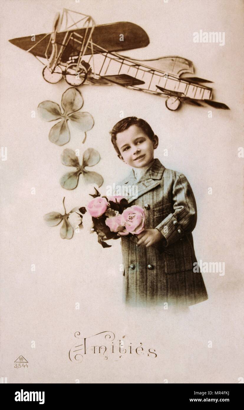 French postcard with image of a boy holding flowers with an aircraft above Stock Photo