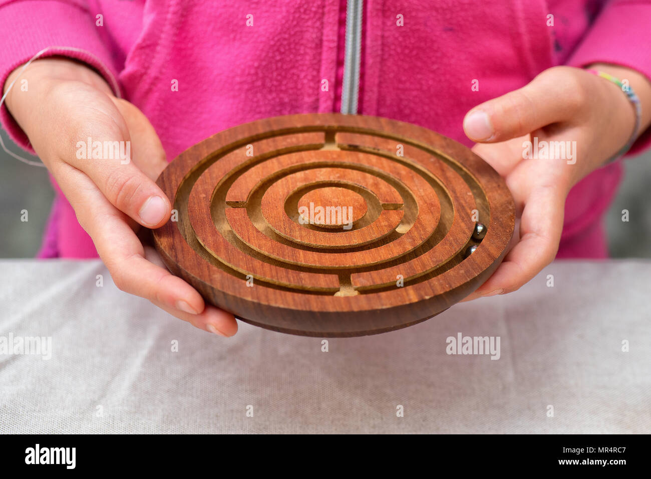 Old wooden game. Labyrinth with rotating metal ball. Stock Photo