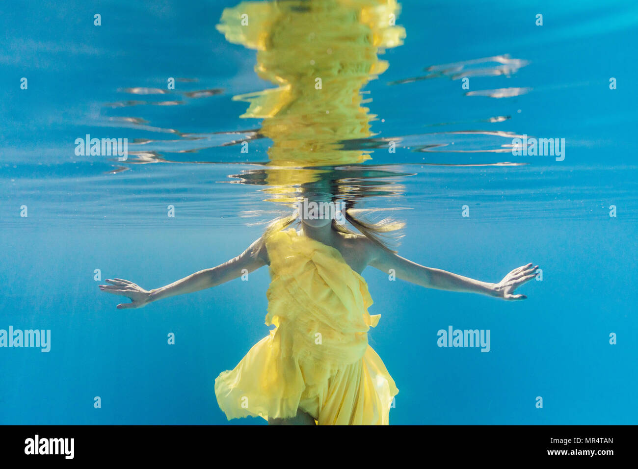 partial view of woman in dress swimming underwater Stock Photo