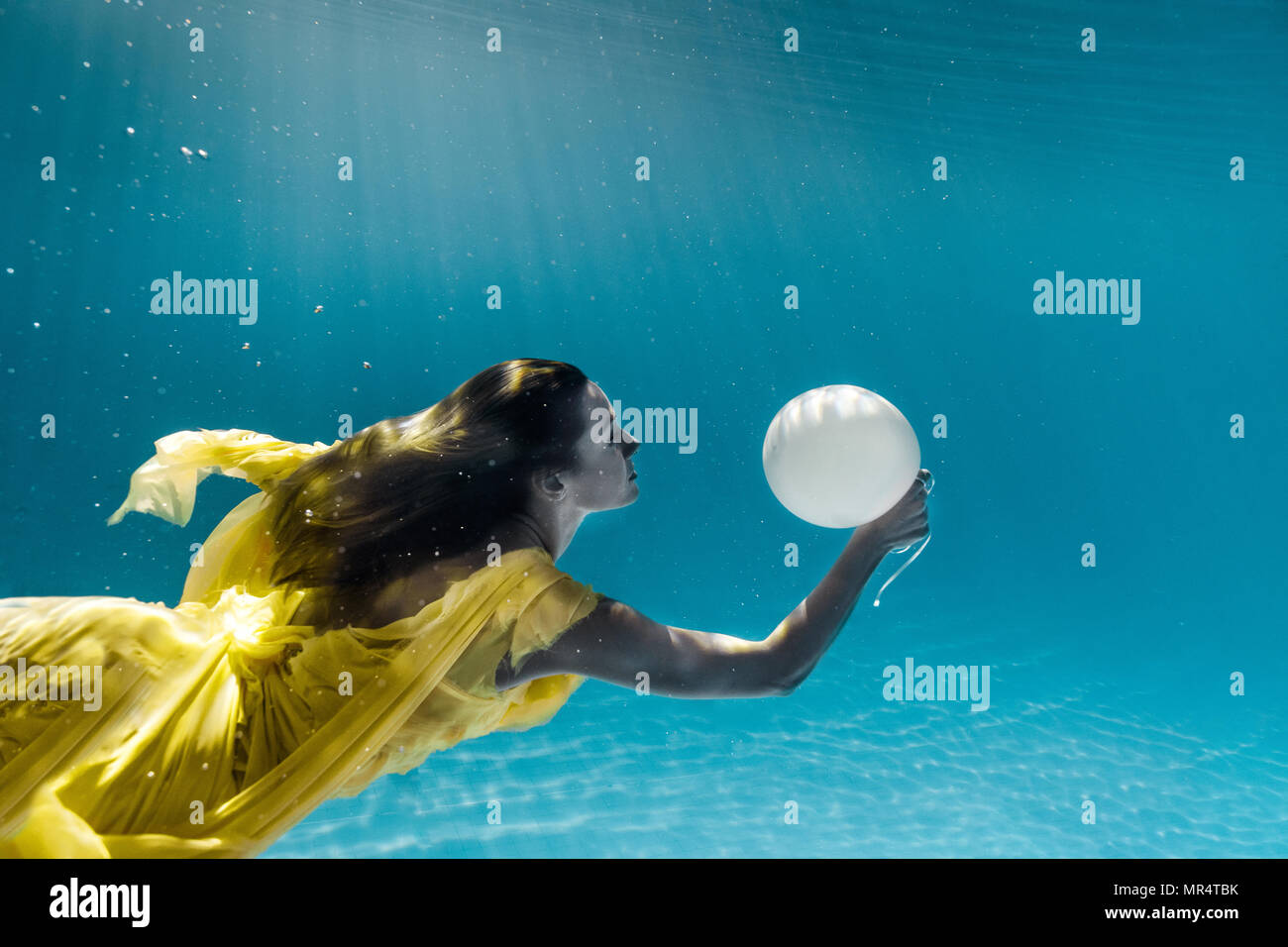 underwater picture of beautiful young woman in dress with balloon swimming  in swimming pool Stock Photo - Alamy