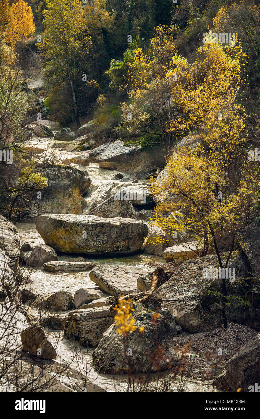 The Orta, a mountain river, flows impetuously among large boulders and plants with autumnal colors. Maiella National Park, Abruzzo, Italy, Europe Stock Photo