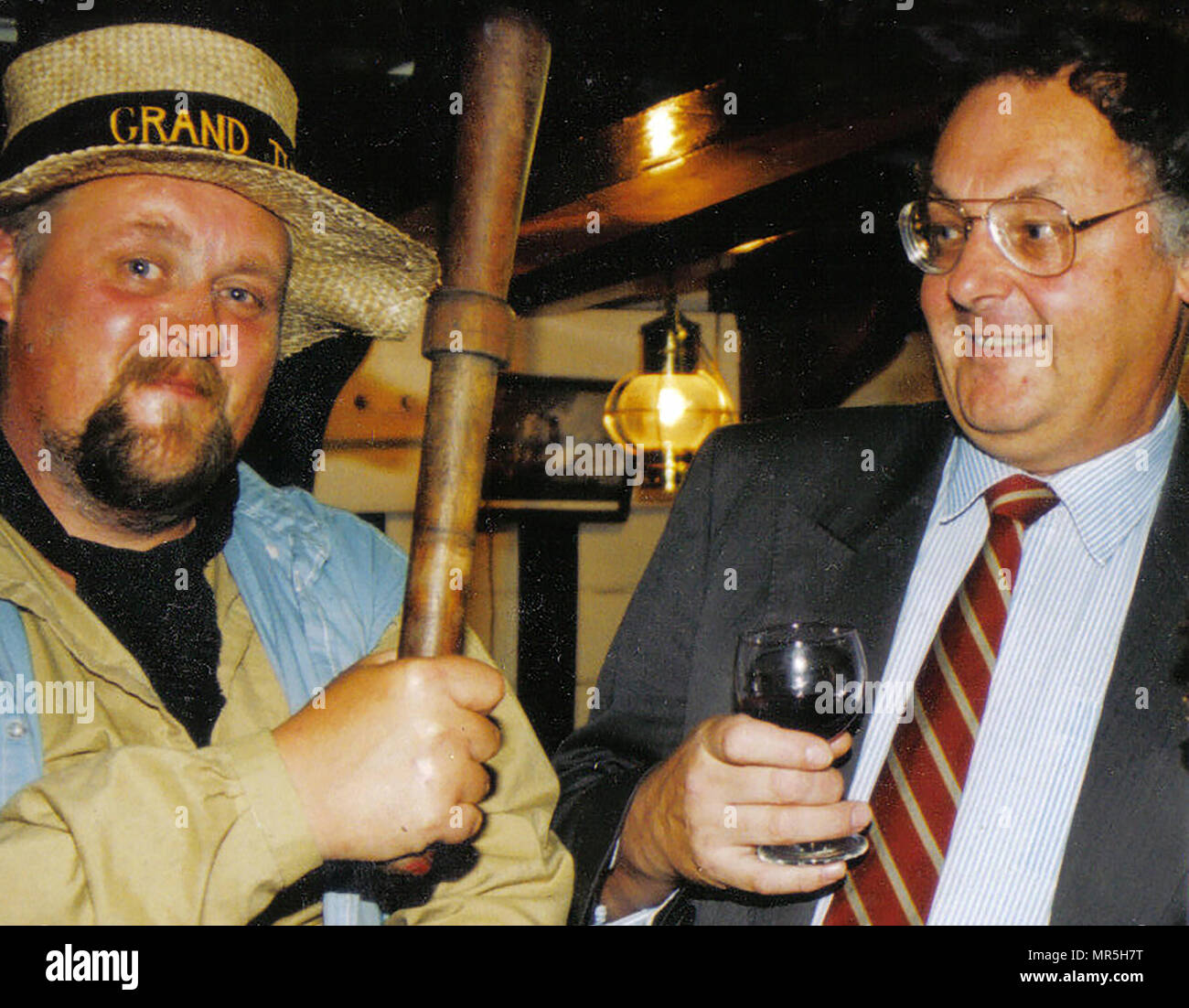 2006 - Visit of the Grand Turk sailing ship to Whitby, Yorkshire, A baton wielding crewman ceremoniously threatens a guest  (Colin Waters, local Archives & Heritage Centre Director) at the official reception below decks. Stock Photo