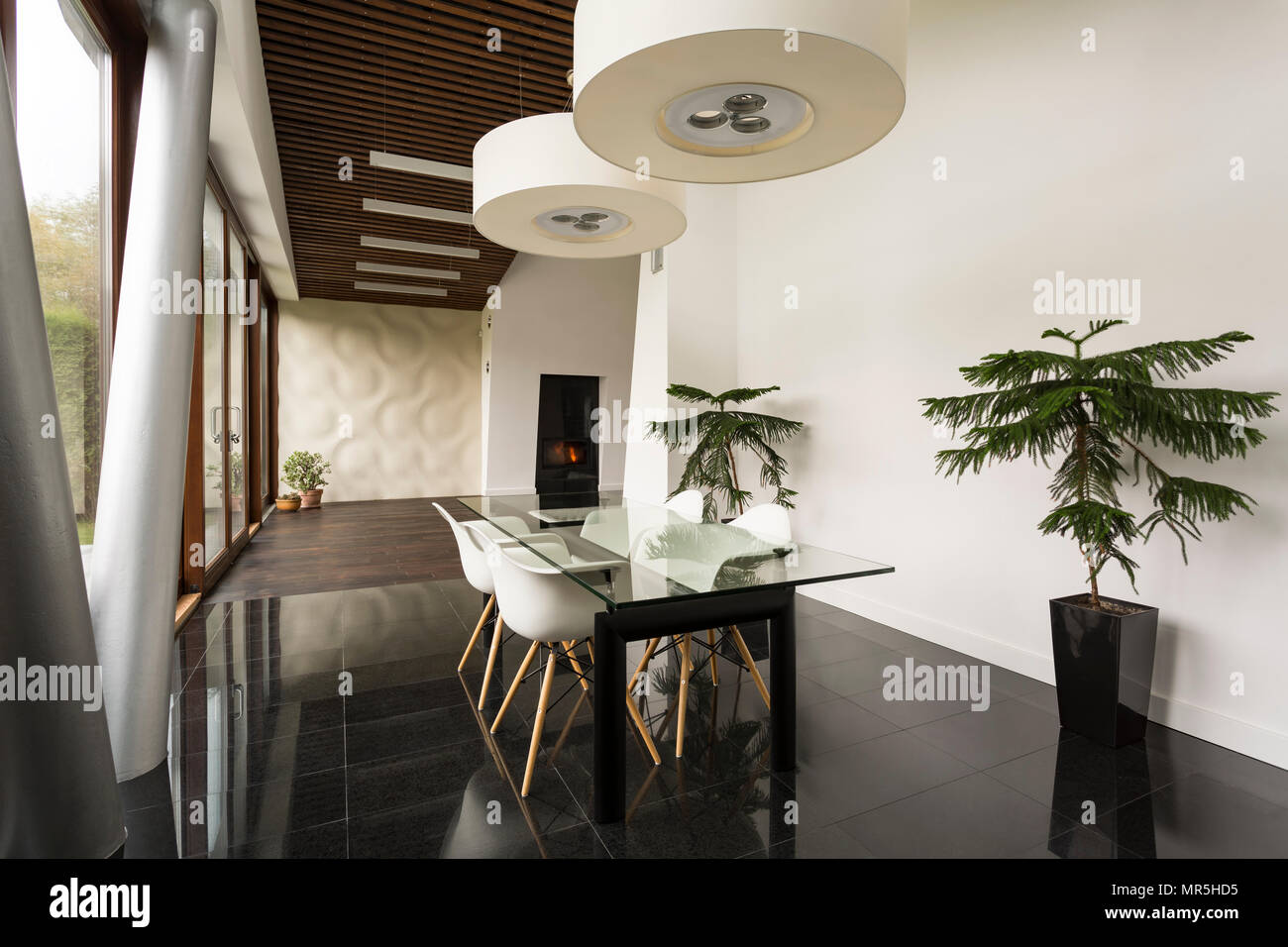 Bright villa interior with glass dining table and white chairs Stock