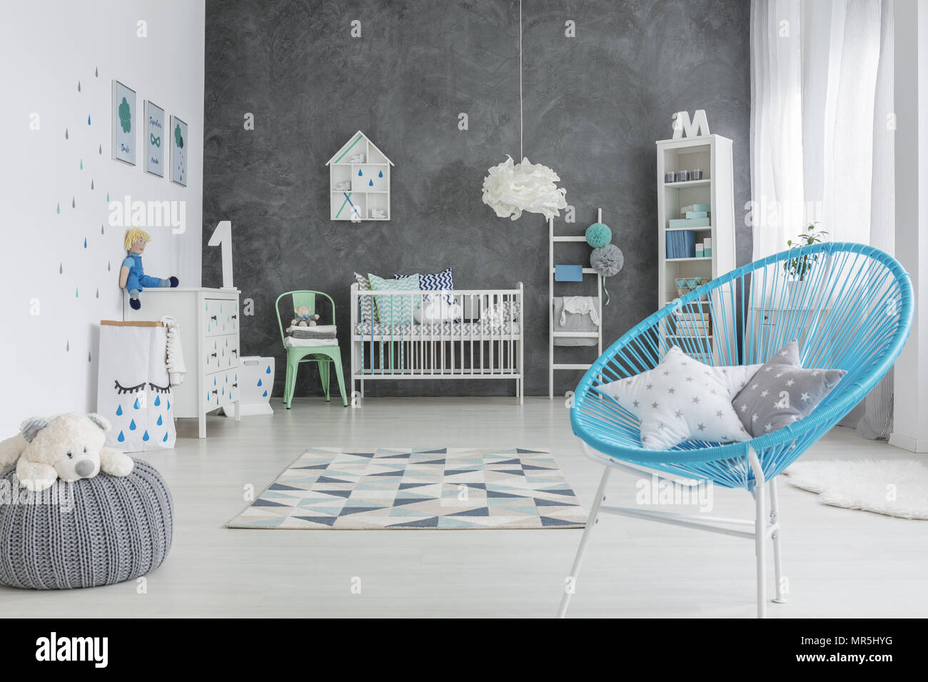 Grey and white baby room with round chair and cot Stock Photo Alamy
