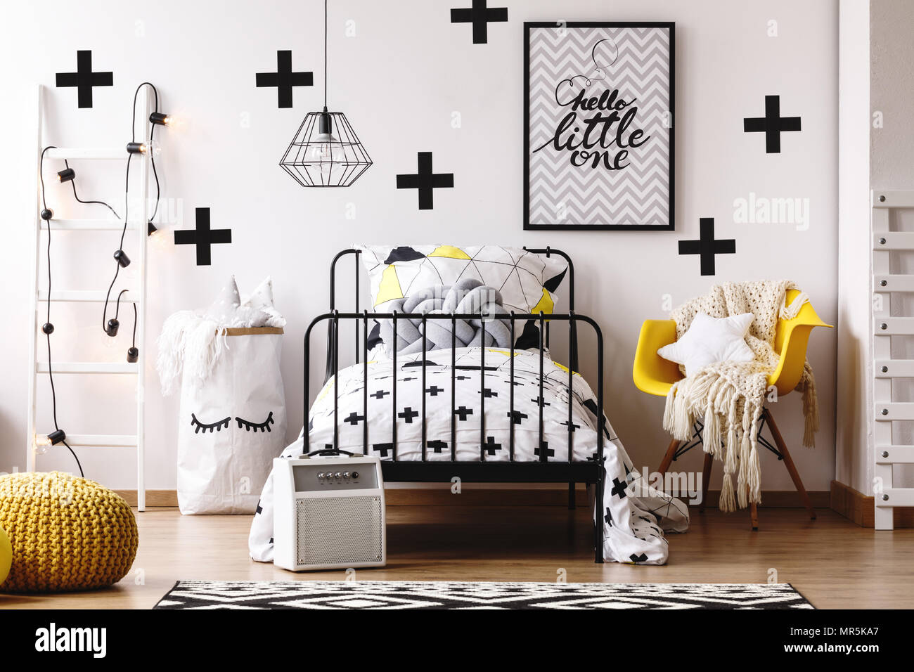 Trendy paper bag for toys next to bed with grey pillow in colorful kids  room with pouf and ladder Stock Photo - Alamy