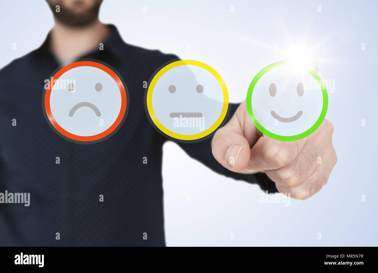 man in blue shirt touching translucent interface with rating smiley buttons,  customer feedback concept Stock Photo