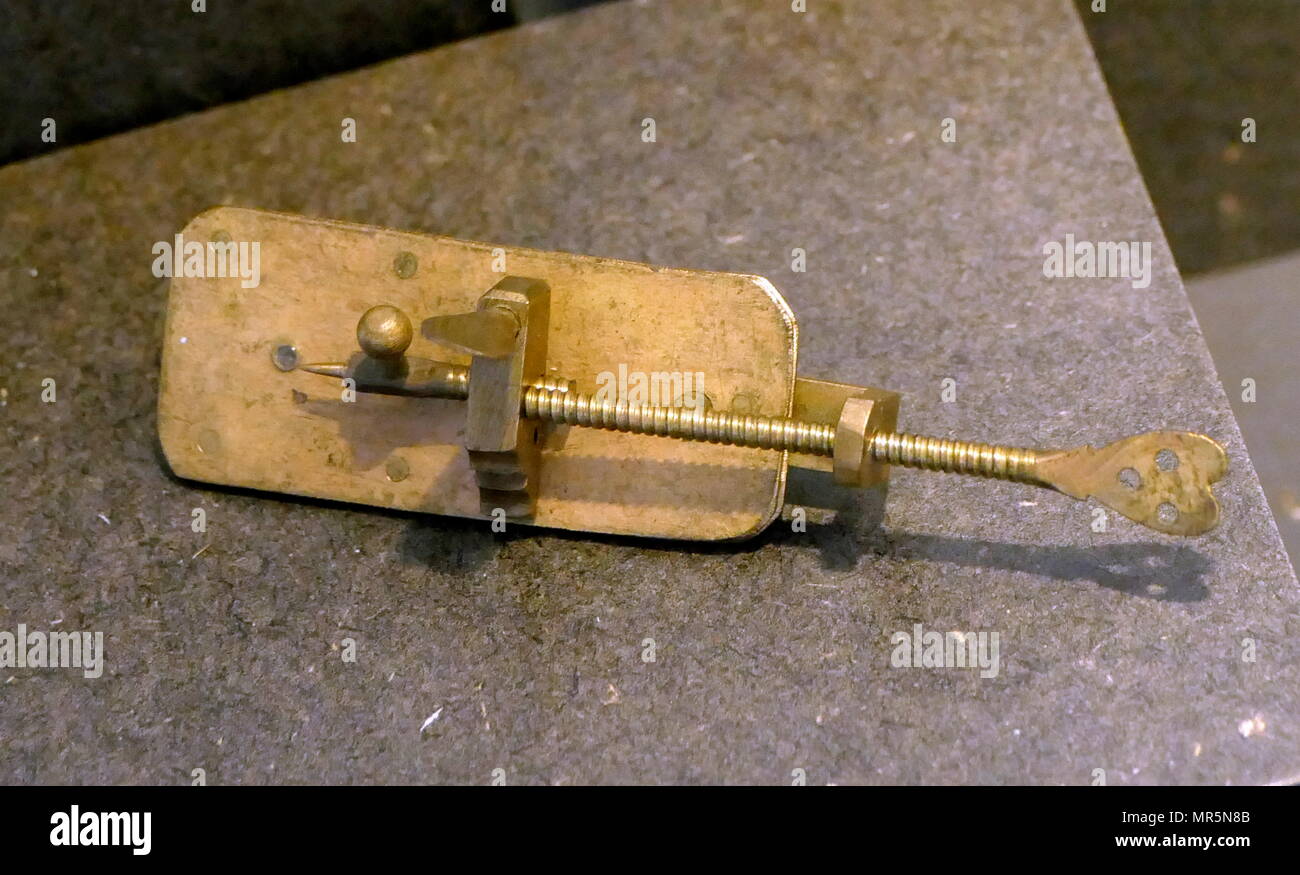 Replica of the first Microscope by Leeuwenhoek. Antonie van Leeuwenhoek who achieved up to 300 times magnification using a simple single lens microscope. He sandwiched a very small glass ball lens between the holes in two metal plates riveted together, and with an adjustable-by-screws needle attached to mount the specimen. Van Leeuwenhoek re-discovered red blood cells and spermatozoa, and helped popularise the use of microscopes to view biological ultrastructure. 1676, Stock Photo