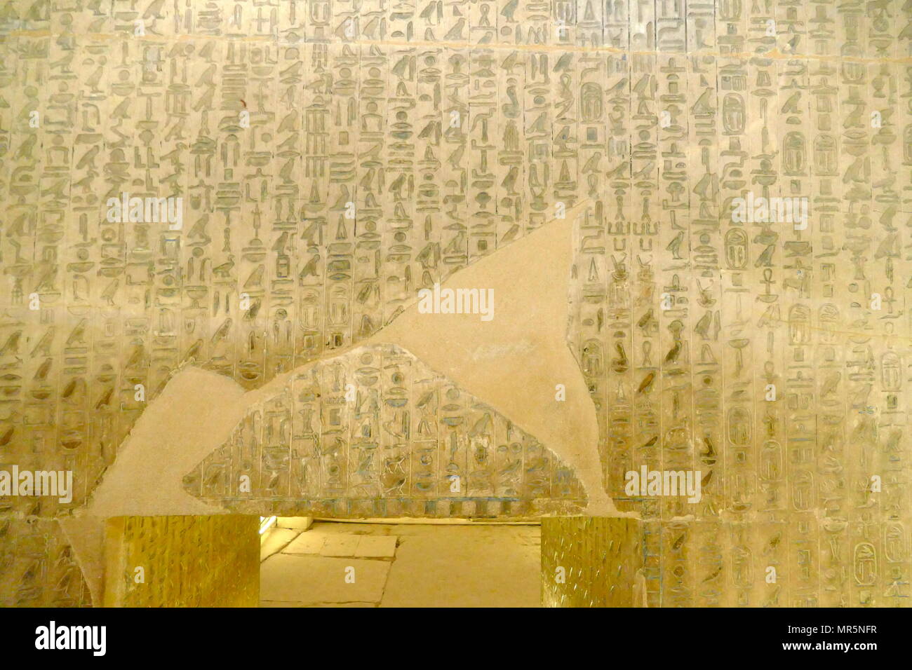 reliefs inside the Pyramid Complex of Unas, at Saqqara, near Cairo in Egypt. It was built for pharaoh Unas, the ninth and final king of the Fifth Dynasty in the mid 24th century BC.  the pyramid of Unas is the first to have texts on the walls of its burial chambers. The spells of these Pyramid Texts were thought to be useful to the dead king in the afterlife; some were recited during his burial ceremonies. The hieroglyphs in Unas' pyramid are incised in fine sunk relief and painted blue, while the ceiling of the sarcophagus chamber is covered with stars Stock Photo