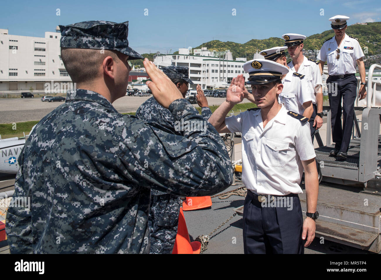 170504-N-XT039-1053 SASEBO, Japan (May 4, 2017) Seaman Recruit Marcel Esquivel, left, from Phoenix, welcomes French sailors assigned to the amphibious assault ship FS Mistral (L9013) as they board the amphibious assault ship USS Bonhomme Richard (LHD 6) for a ship’s tour. Bonhomme Richard, forward-deployed to Sasebo, Japan, is serving forward to provide a rapid-response capability in the event of a regional contingency or natural disaster. (U.S. Navy photo by Mass Communication Specialist Seaman Jesse Marquez Magallanes/Released) Stock Photo