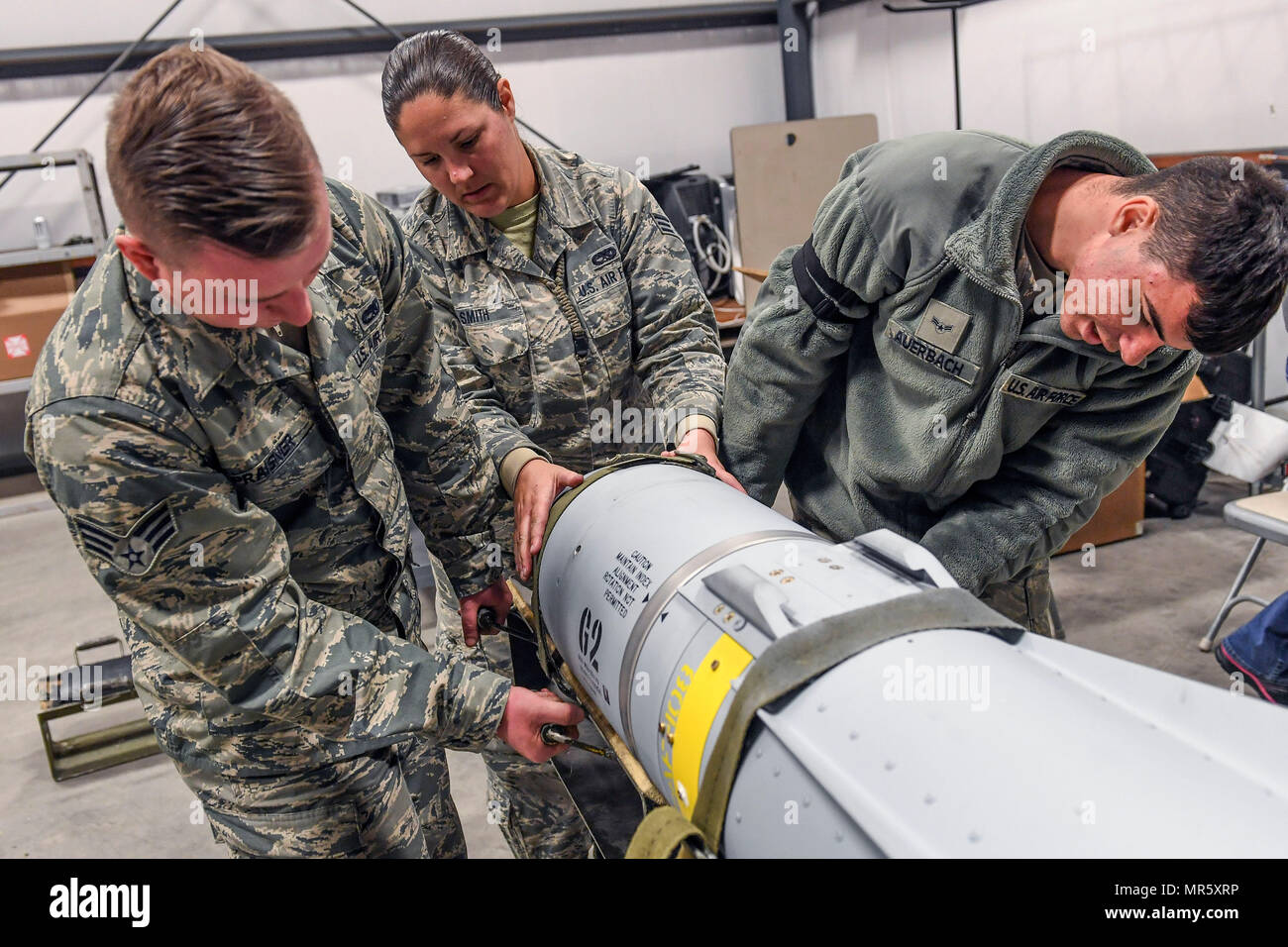 From the left, Senior Airman Troy Praisner, Senior Airman Lauren Smith and Airman 1st Class Anthony Auerbach, all from the 23rd Equipment Maintenance Squadron, Moody Air Force Base, Georgia, remove the guidance control system from an AGM-65 Maverick air-to-surface guided missile at Hill Air Force Base, Utah, April 26. The Airmen participated in Combat Hammer, an air-to-ground weapons evaluation exercise conducted by the 86th Fighter Weapons Squadron which collects and analyzes data on the performance of precision weapons and measures their suitability for use in combat.  (U.S. Air Force/Paul H Stock Photo