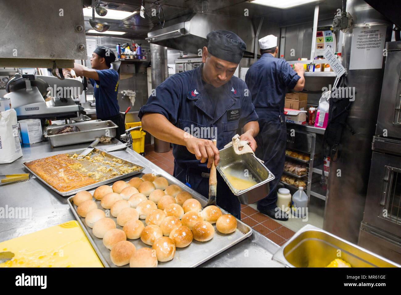170514-N-BV658-129     SOUTH CHINA SEA(May 14, 2017)   Jun Alejandrino, a native of the Philippines, prepares dinner rolls in the galley aboard the Arleigh Burke-class guided-missile destroyer USS Dewey (DDG 105).  Dewey is part of the Sterett-Dewey Surface Action Group and is the third deploying group operating under the command and control construct called 3rd Fleet Forward.  The U.S. 3rd Fleet operating forward offers additional options to the Pacific Fleet commander by leveraging the capabilities of 3rd and 7th Fleets. (U.S. Navy Photo By Mass Communication Specialist 3rd Class Kryzentia W Stock Photo