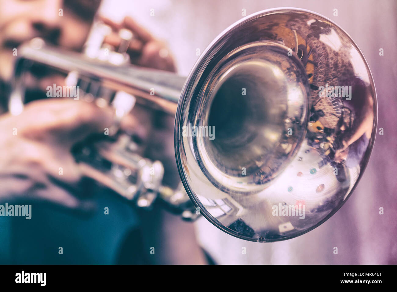 The trumpeter is playing on a silver trumpet. Trumpet player Stock